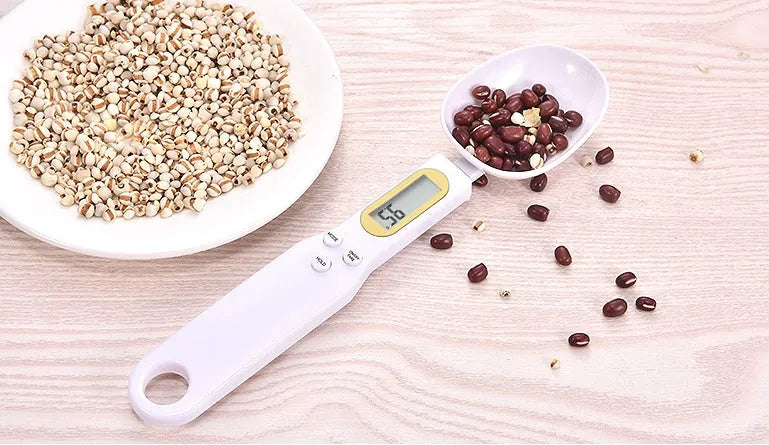 Black digital measuring spoon scale showing 0.0g display on LCD screen with 500g capacity