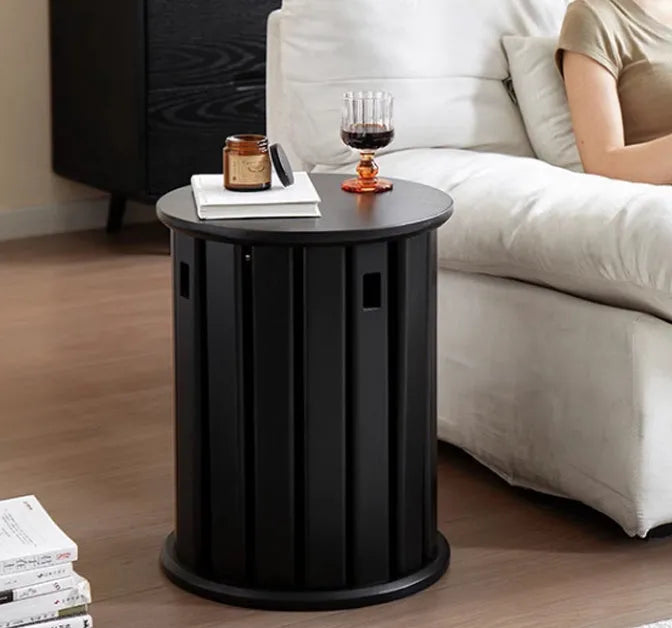 Stackable round iron dining stool in smoked black, walnut, cherrywood, or cream colour on a tiled floor.