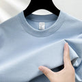 Men's solid colour cotton t-shirt with drop shoulder design on a hanger.