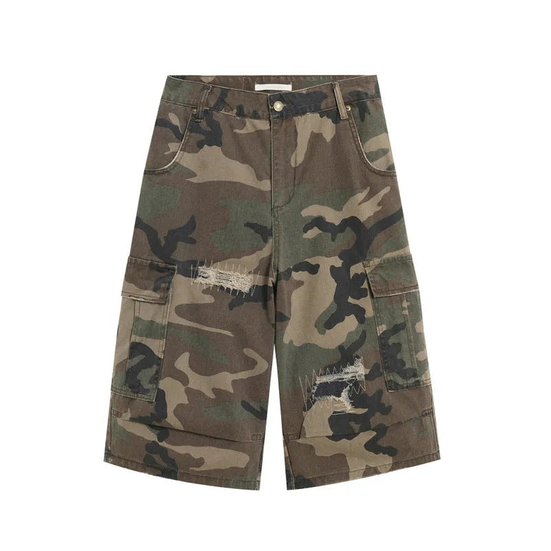 Men's loose-fit camouflage cropped jeans with ripped details and patches on a straight leg.