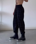 Men's loose-fitting plaid trousers with apron-style front waistband