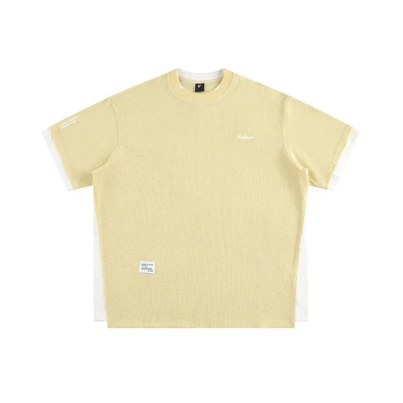 Loose grey waffle-texture T-shirt with embroidered retro alphabet design on the front.