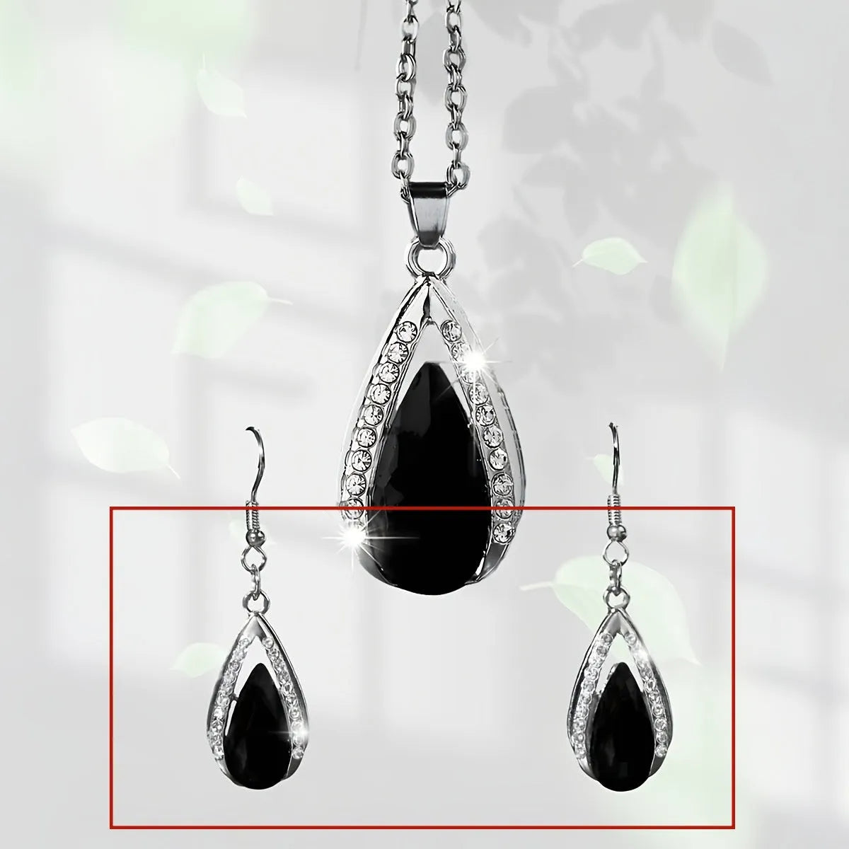 Black and red teardrop-shaped glass pendant necklace and matching earrings set on alloy chain.