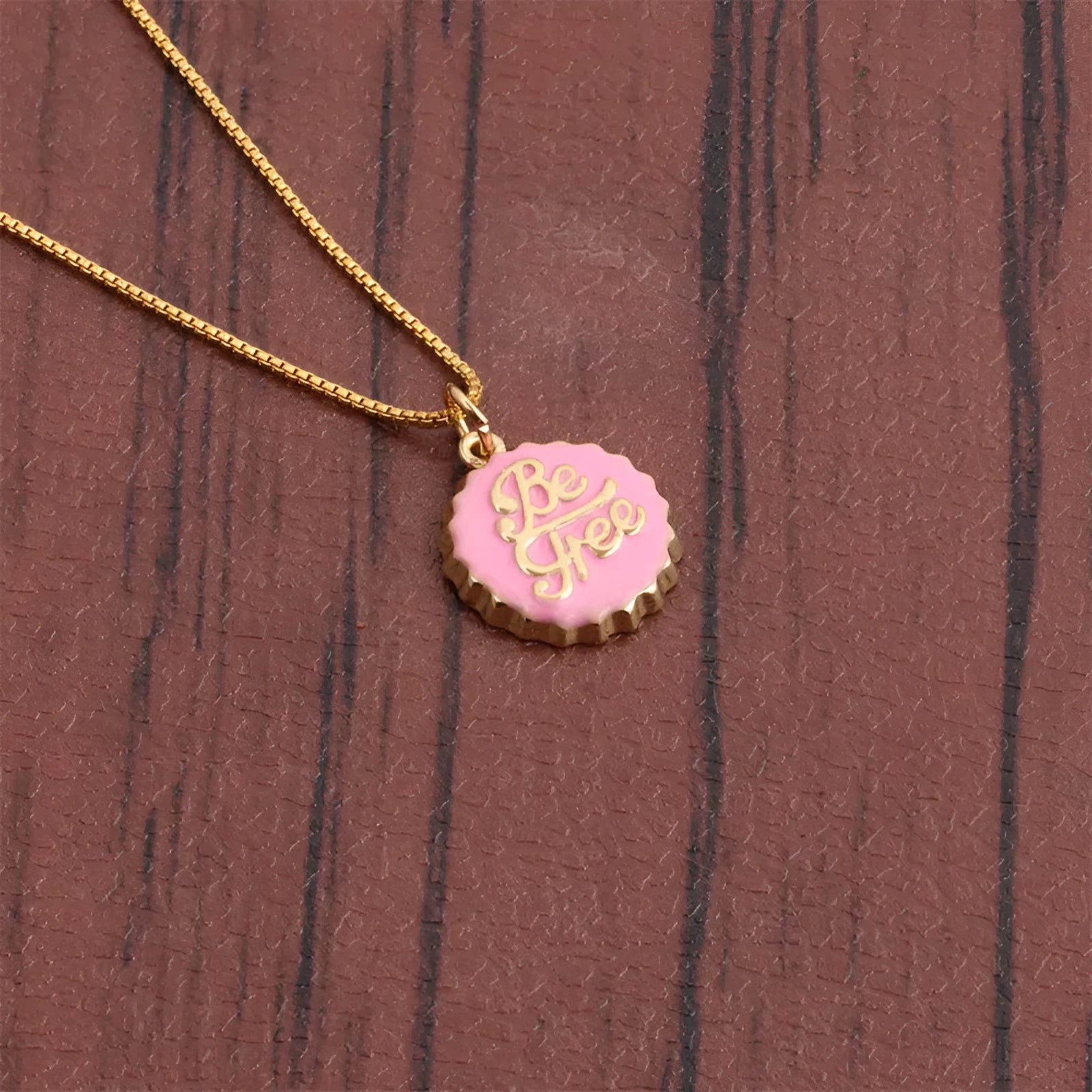 Copper bottle cap pendant necklace on a box chain, showing the detailed pendant shape.