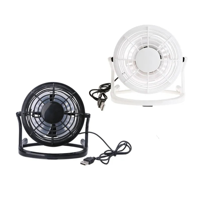 Mini black USB desk fan with adjustable head on a desk next to a laptop.