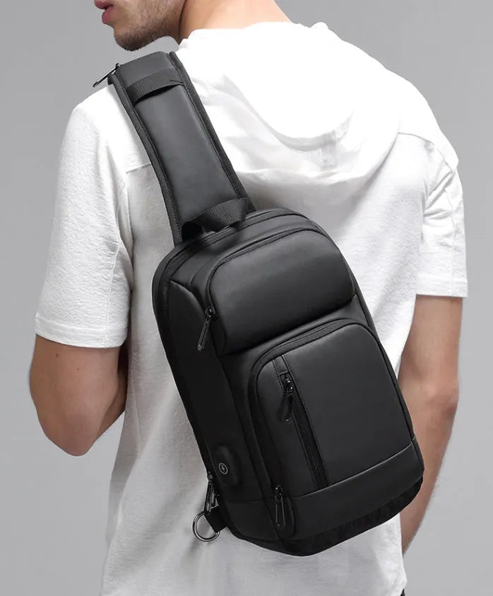 Black medium outdoor PVC shoulder bag with an air cushion strap and organiser pockets.