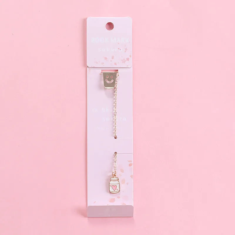 Cartoon-themed alloy metal bookmark charm on a book page.