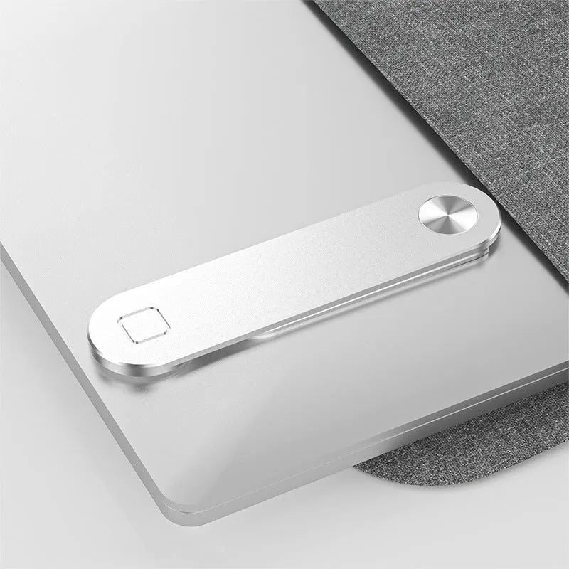 Black magnetic phone holder attached to side of silver laptop, showing phone mounted.