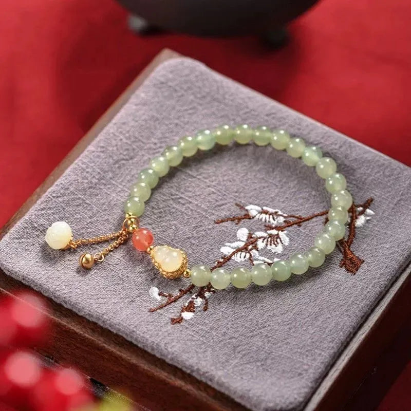 Natural jade bead bracelet with a gold-plated gourd charm and fu character.