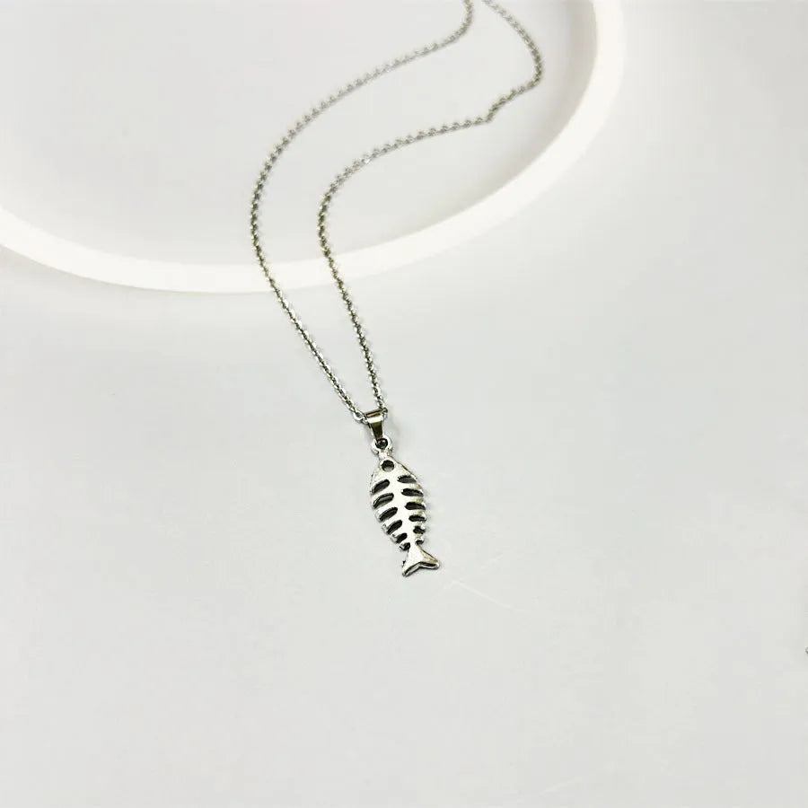Fishbone pendant necklace and matching earrings set with adjustable chain on retro background