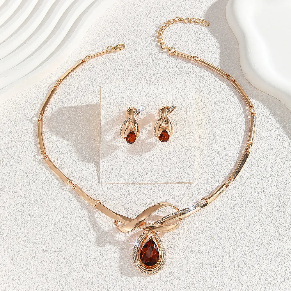 Gold alloy necklace and earrings suite with white rhinestone and brown crystal fan-shaped centrepiece on a white background