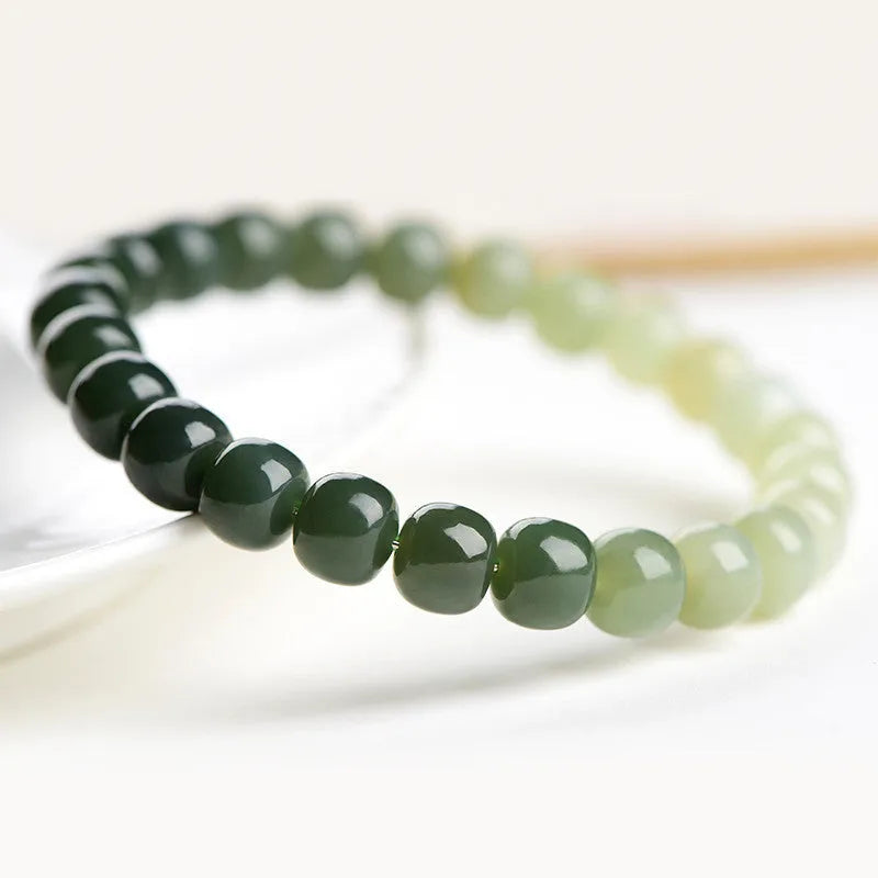 Natural Hetian jade bracelet with gradient clear water colour on a wrist.