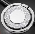 Sparkling bling glitter metal phone holder ring showing rotation, attached to a smartphone.