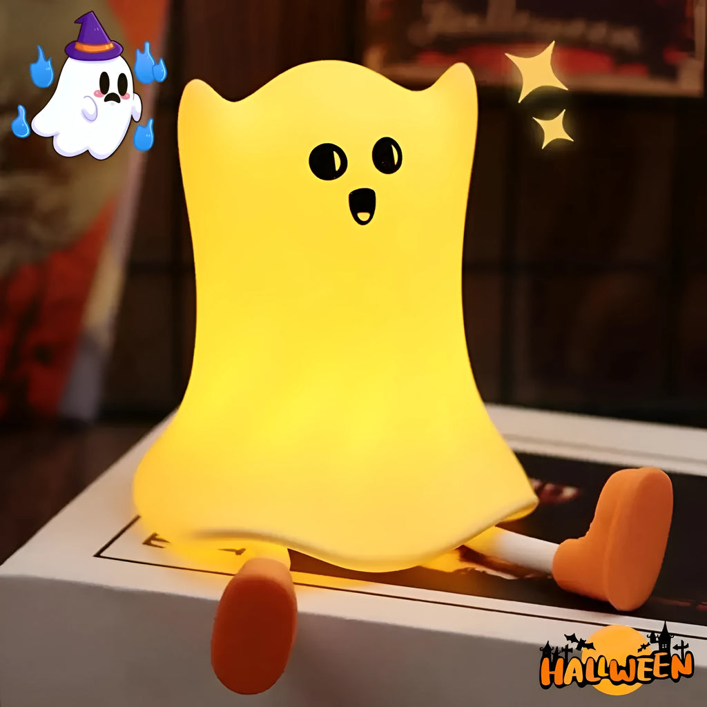 Ghost shaped silicone bedside lamp with touch control emitting soft yellow glow on a bedside table