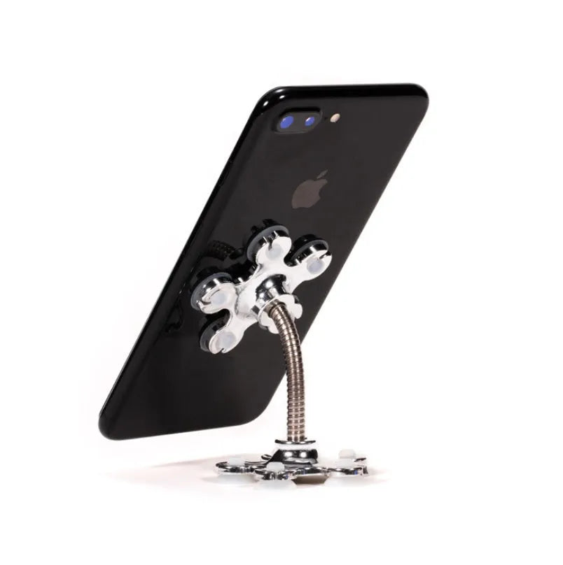 Double-sided silicone suction phone holder in silver-white on a desk, measuring 8x5.5cm