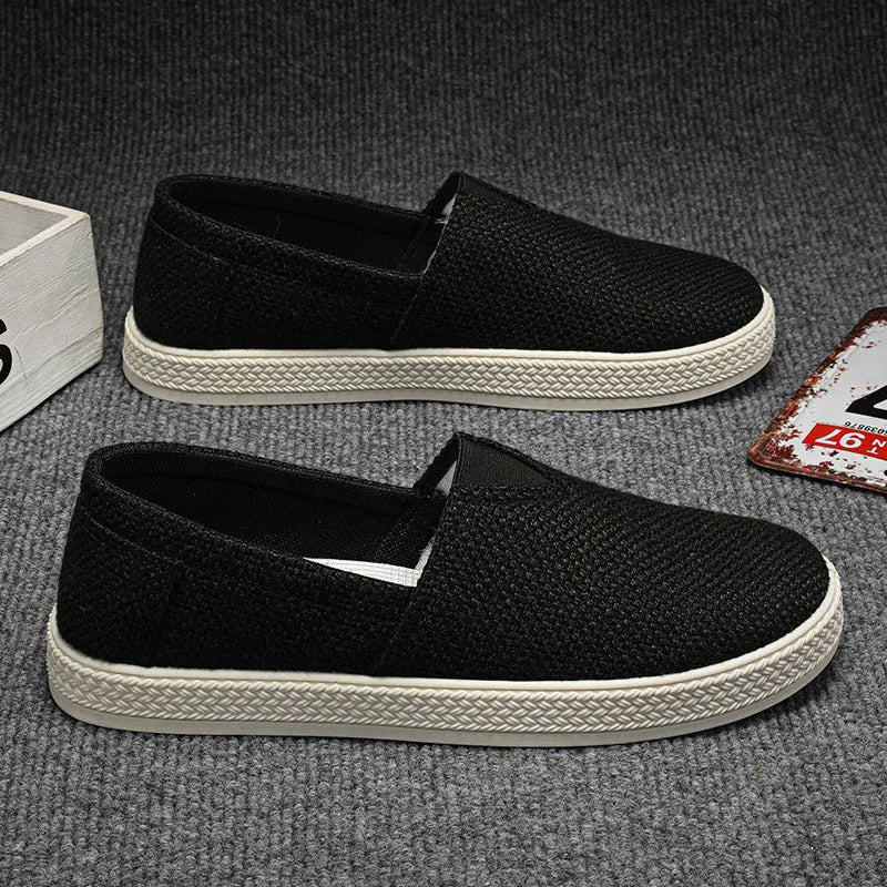 Men's beige canvas slip-on shoes with round toe and PVC sole.