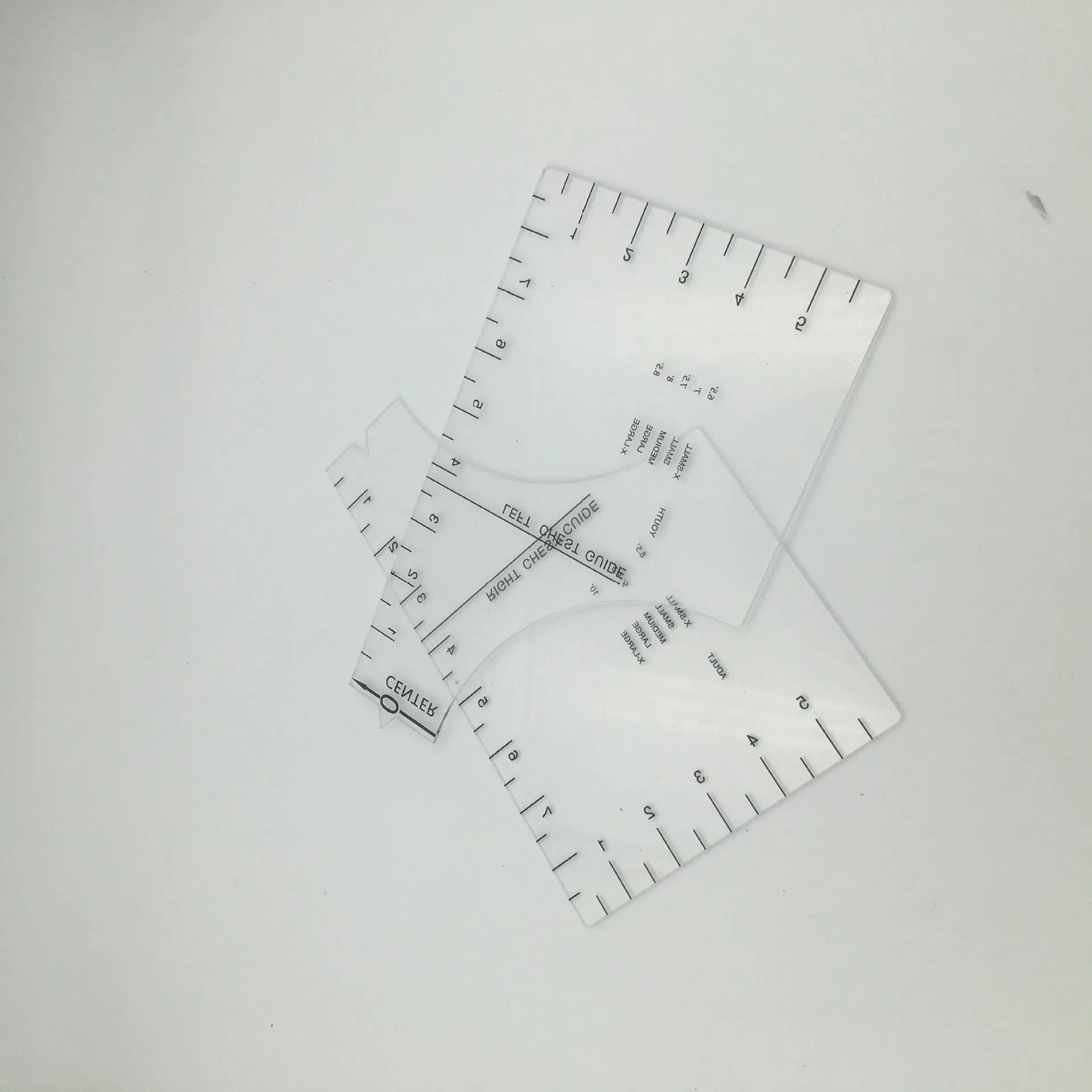 Transparent acrylic sewing ruler for T-shirt alignment and patch placement on fabric.