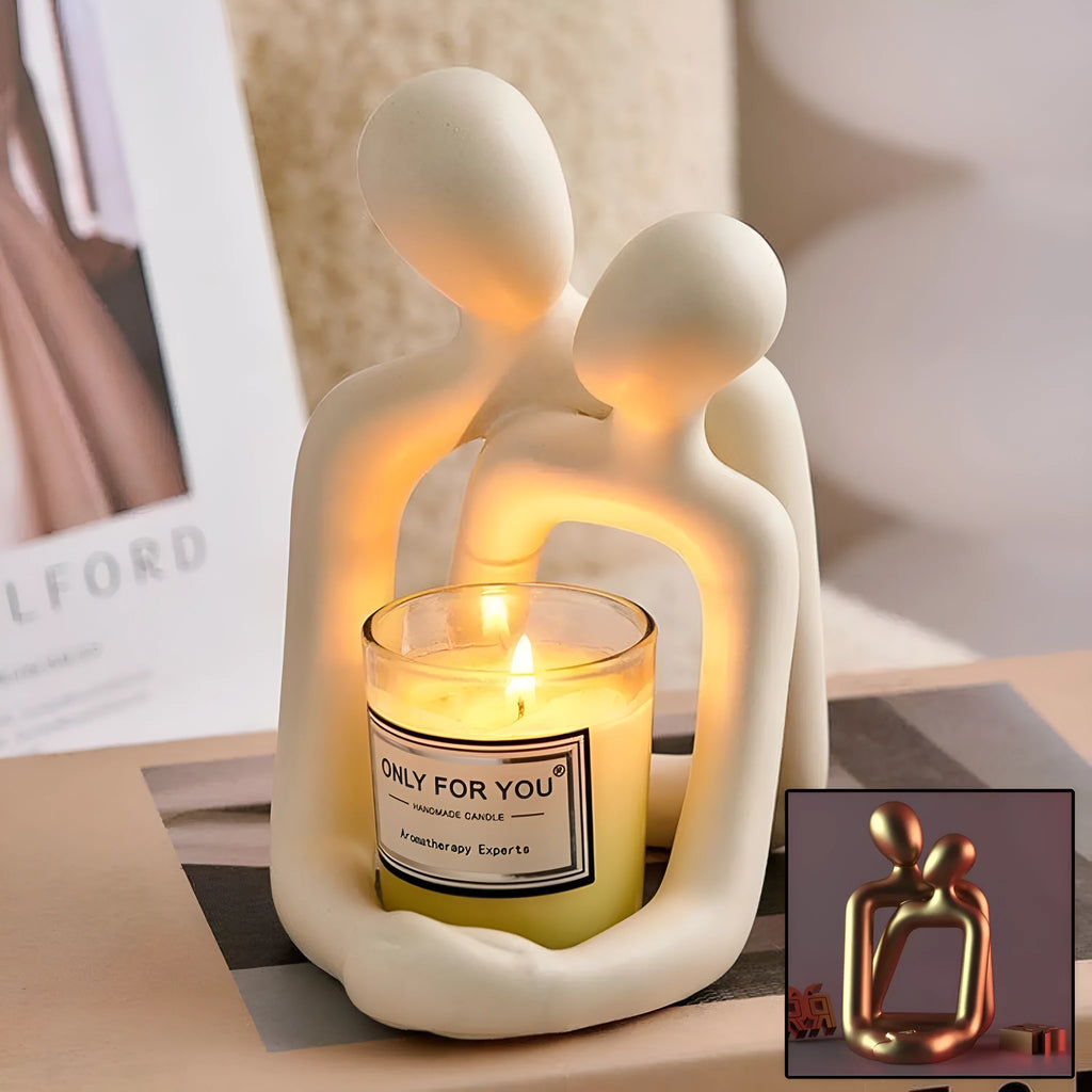 Modern resin statue of a loving couple in gold or milky white colour on a wooden surface.