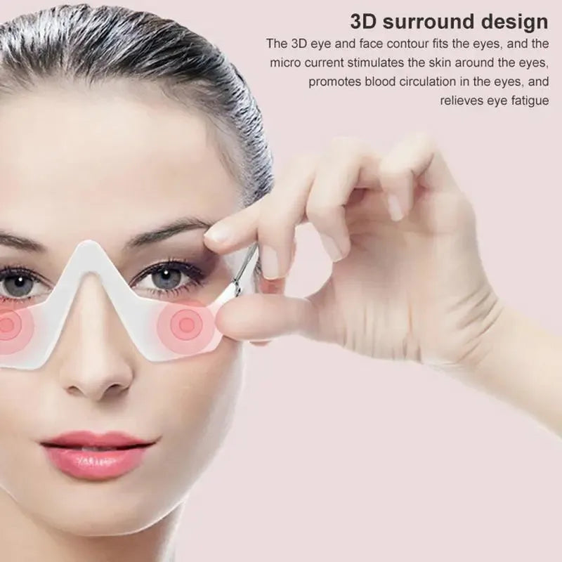 Pink and white 3D micro-current eye massager with glasses-style design on a grey background.