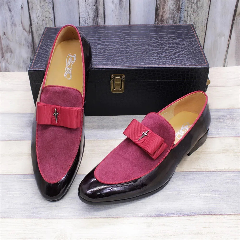 Men's black patent leather tassel loafers with a matte toe, shown on a wooden floor.