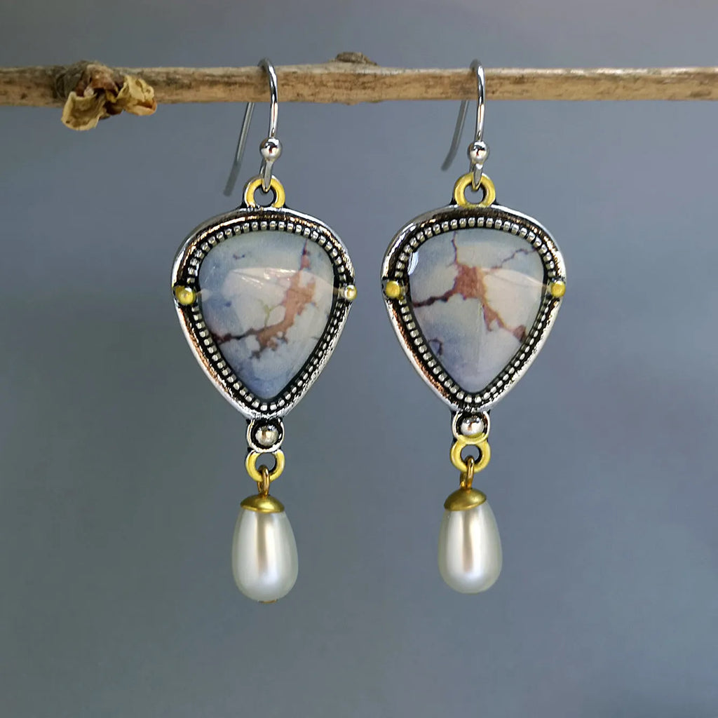 Retro blue drop earrings with synthetic blue opal and white pearl on a geometric metal setting.