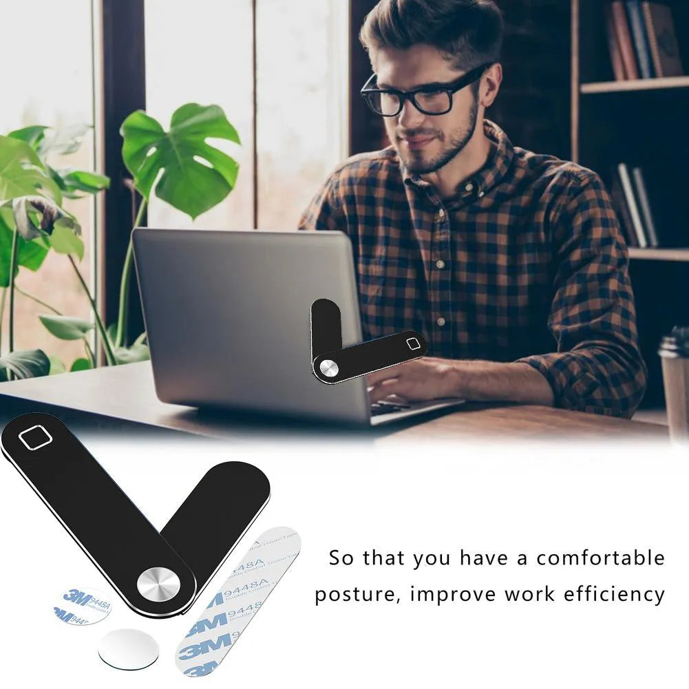 Black magnetic phone holder attached to side of silver laptop, showing phone mounted.