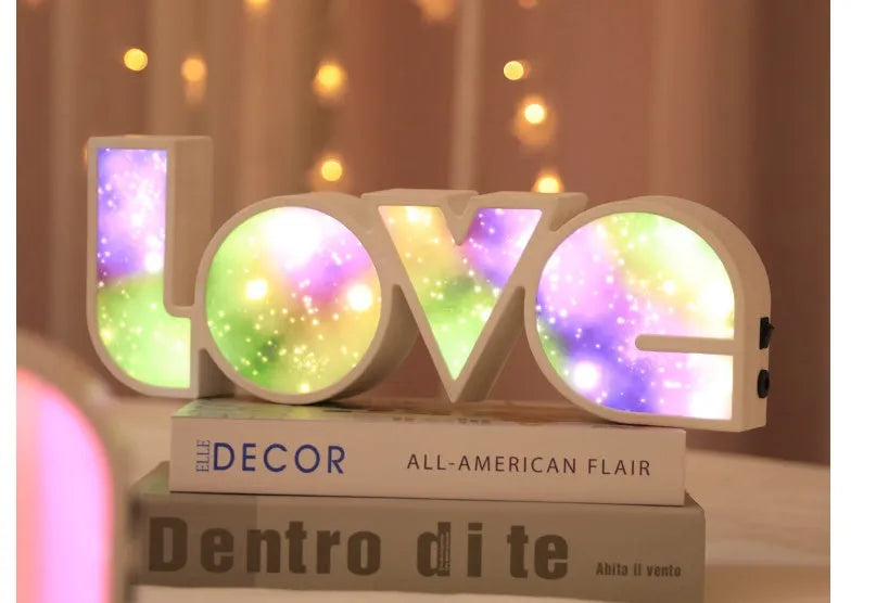 Rainbow colour LED LOVE light decoration for Valentine's Day or weddings on a desk.