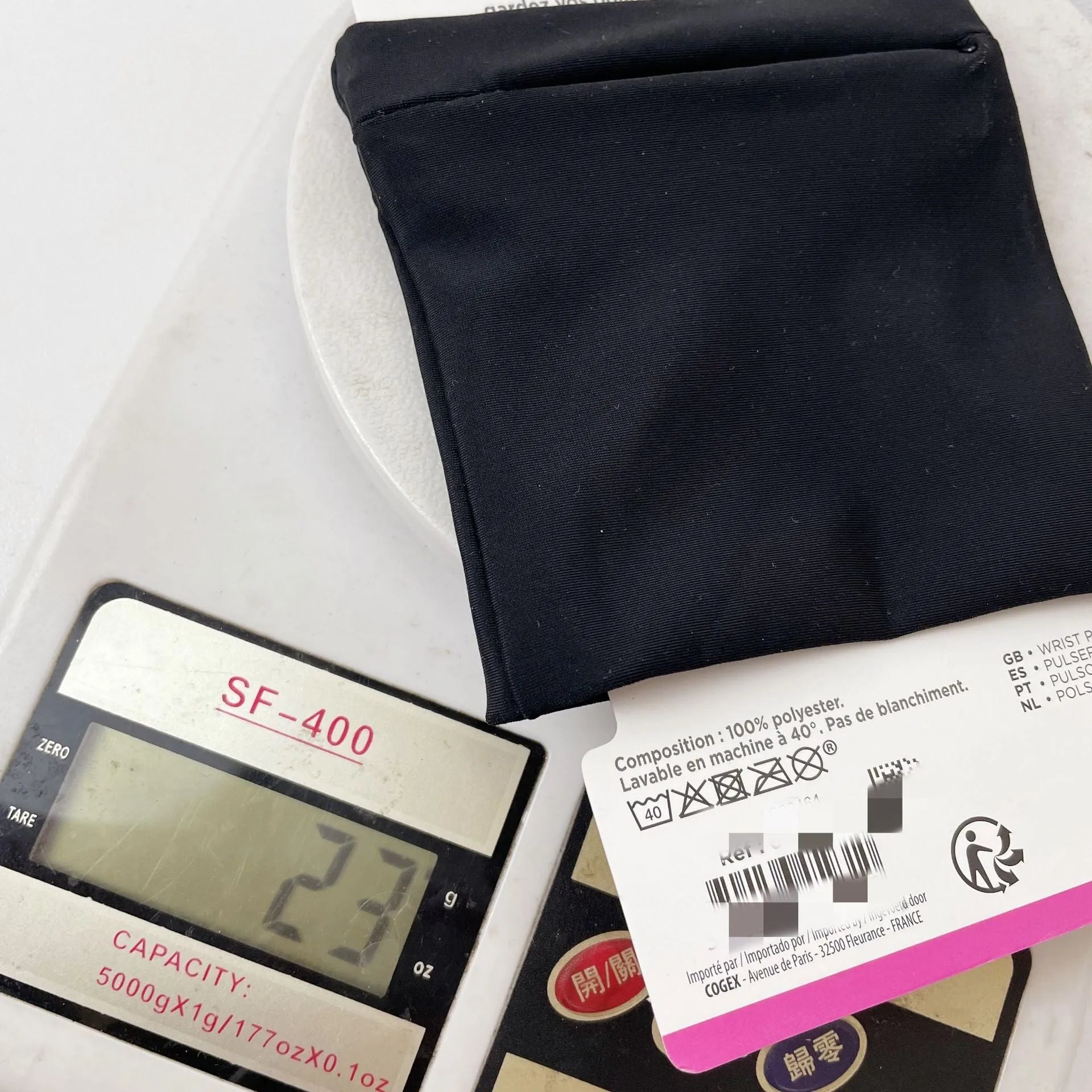 Black wrist bag armband sleeve with adjustable strap, shown holding a mobile phone, dimensions 10x10.5cm.