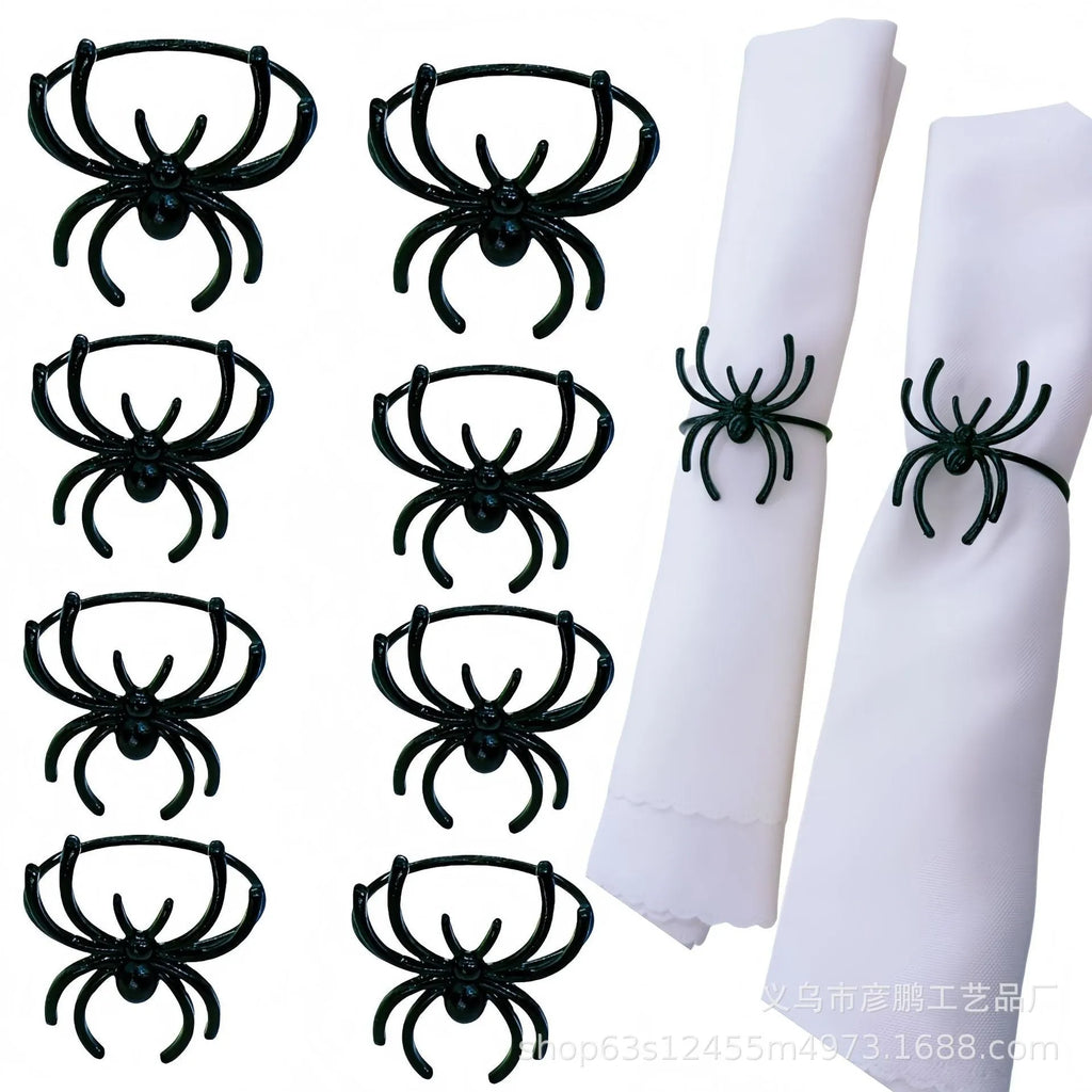 Set of six black alloy Halloween napkin rings with detailed spider design on a table setting.
