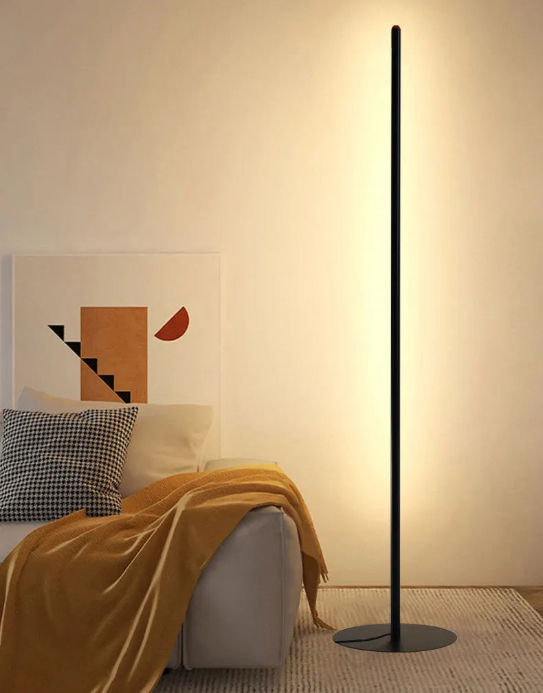 Vertical aluminium alloy floor lamp in modern simplicity style on a table.