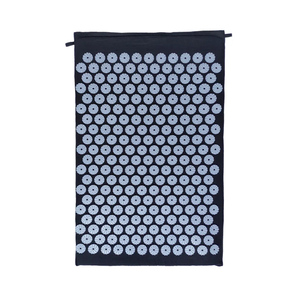 Black and blue acupuncture massage mat set with cushion and headrest on floor for yoga and massage