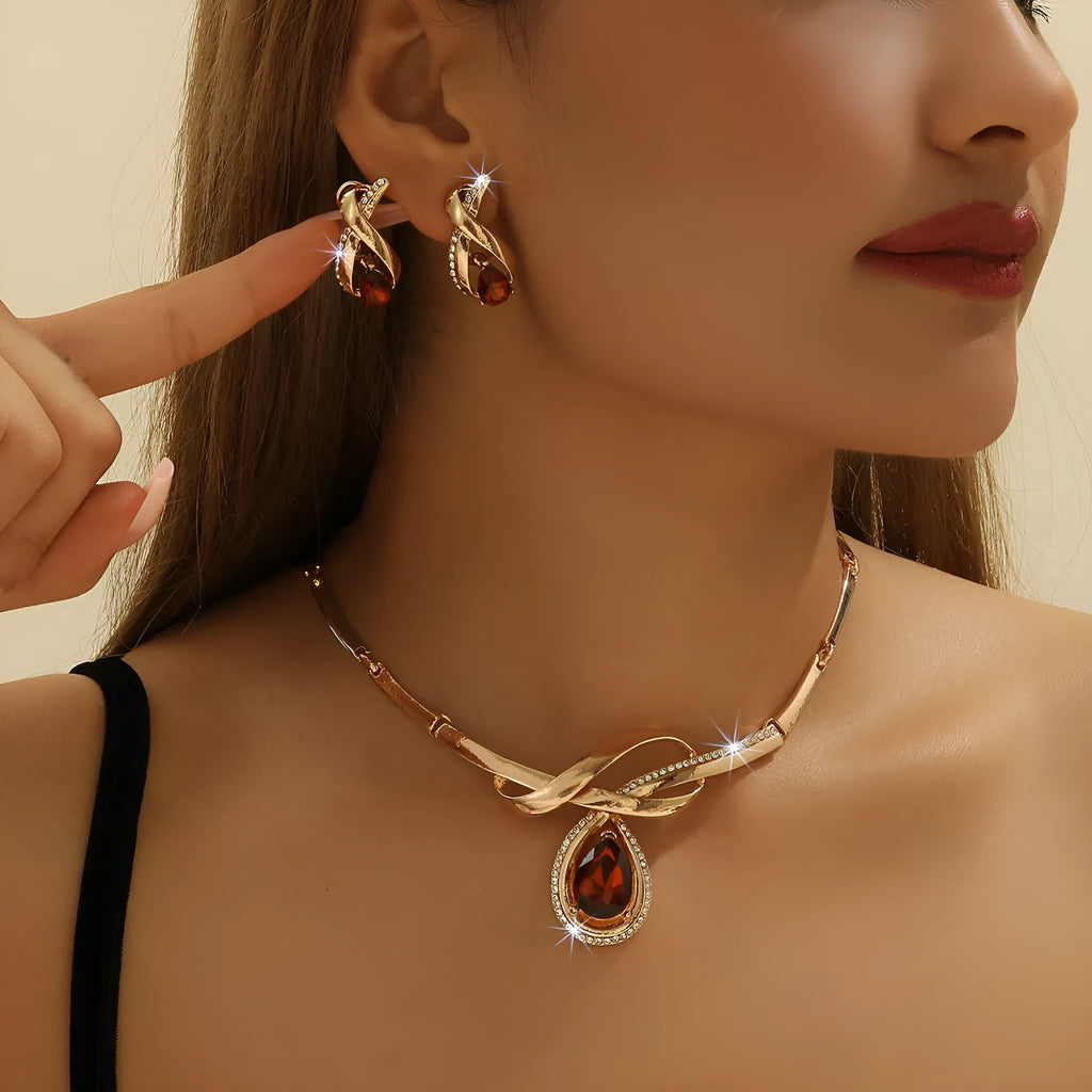 Gold alloy necklace and earrings suite with white rhinestone and brown crystal fan-shaped centrepiece on a white background