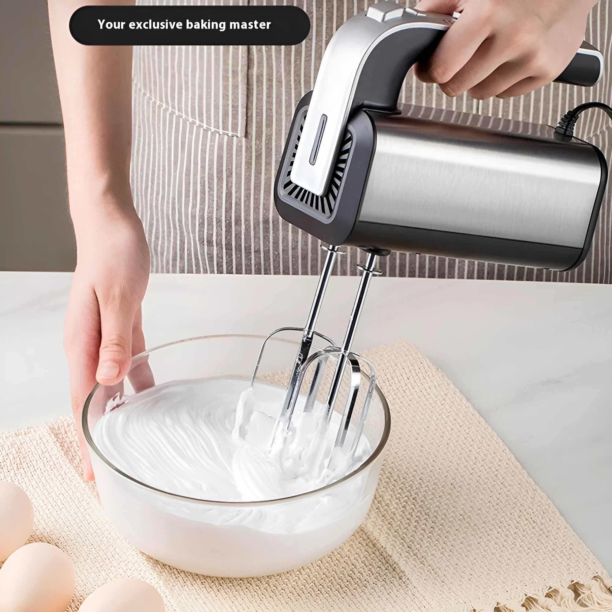 Silver handheld electric whisk with five speed settings and dual voltage compatibility