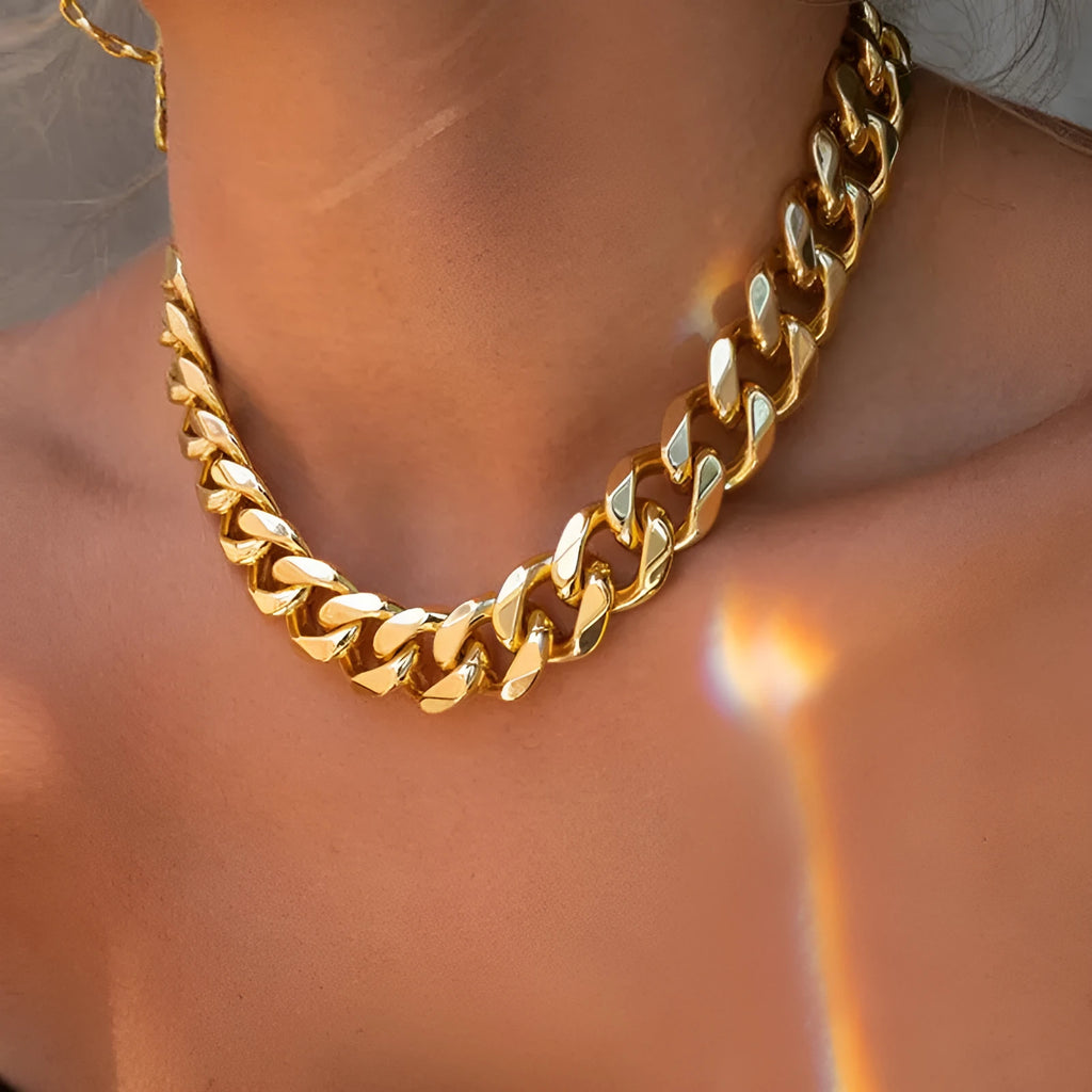 Gold-toned women's thick chain necklace with an integrated rectangular pendant, shown on a plain background.