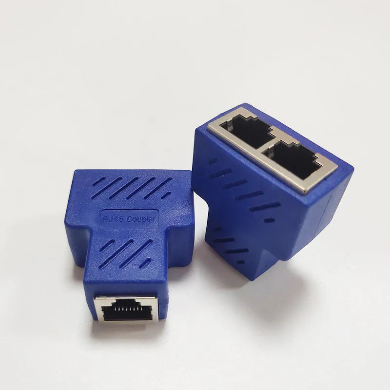 White RJ45 three-way tee network cable splitter adapter on a table.