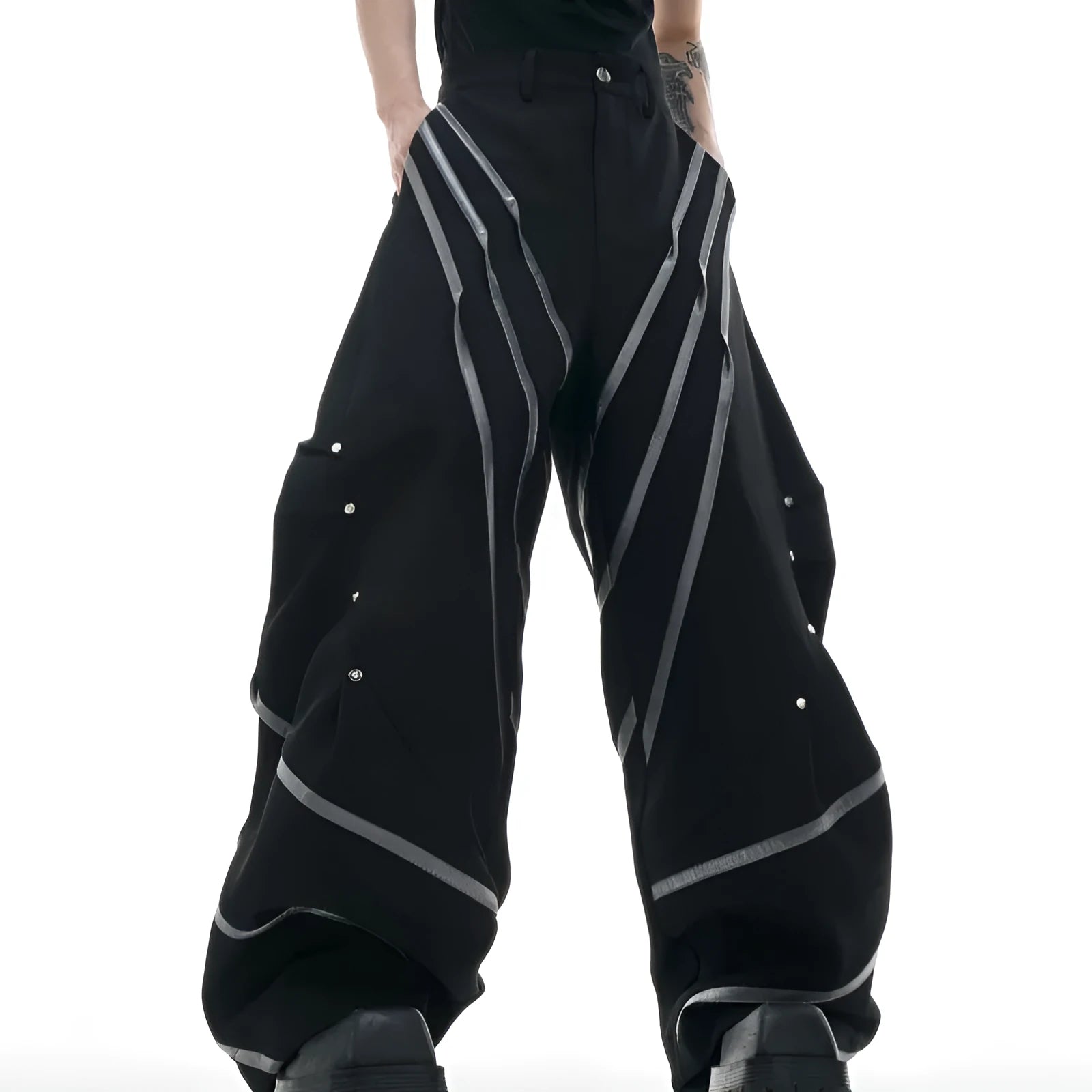 Men's black polyester trousers with metal rivet stripe and front pleats on a white background.