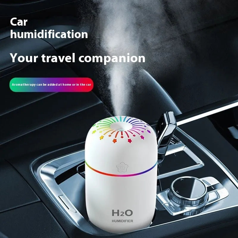 White USB mini humidifier with 300ml tank on a desk next to a laptop.