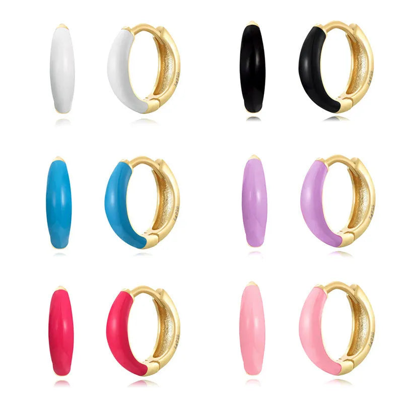 A pair of oval-shaped epoxy resin earrings on a U-shaped curved silver hook, showing a marbled colour finish.