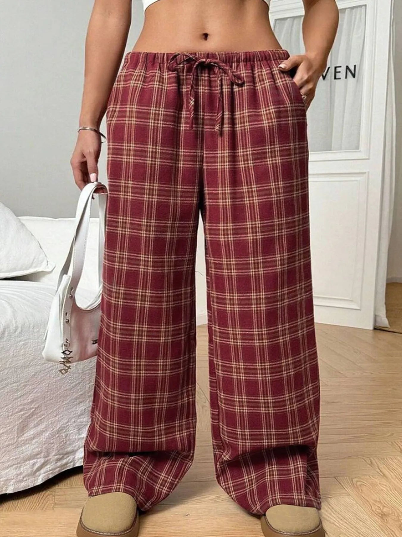 Blue women's loose fit casual trousers with a drawstring waist and front pockets on a hanger.