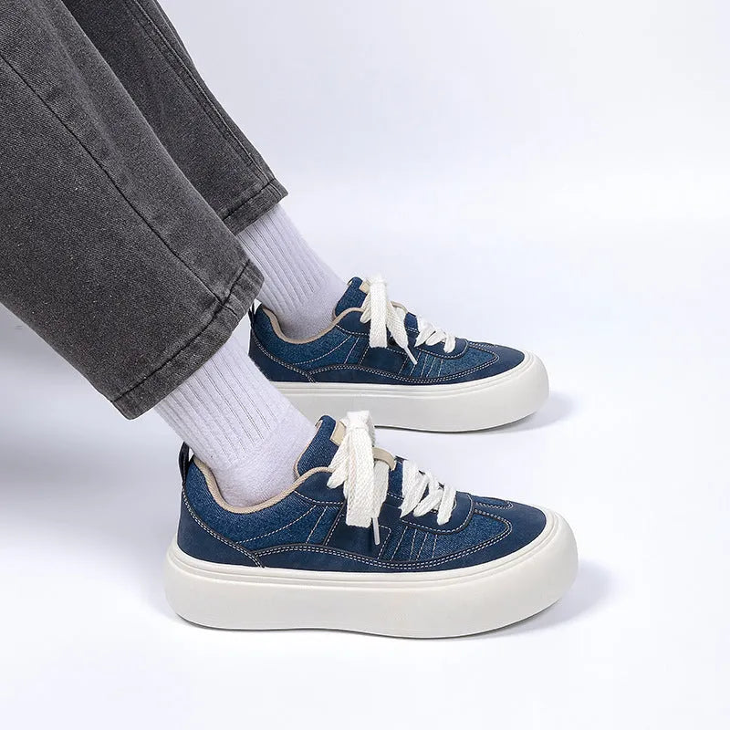 Men's black canvas platform sneakers with round toe and lace-up front on grey background