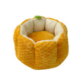Orange pumpkin-shaped pet bed nest for cats and small dogs on a wooden floor.