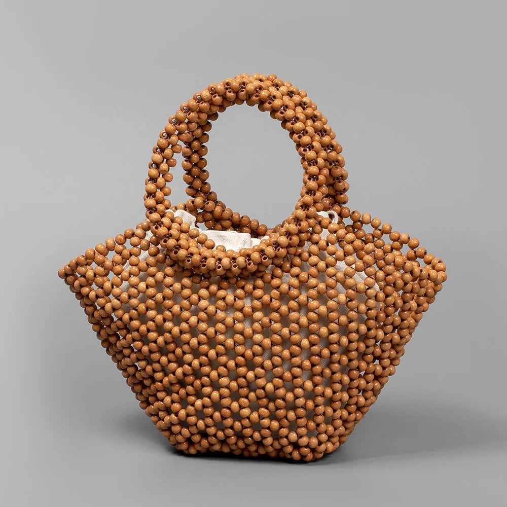 Hand-woven wooden bead beach bag in dumpling shape with strapless design.