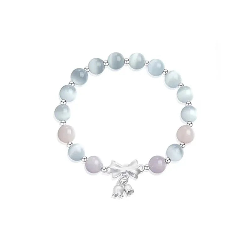 Lavender amethyst opal bracelet with a silver-toned bowknot design on a wrist.