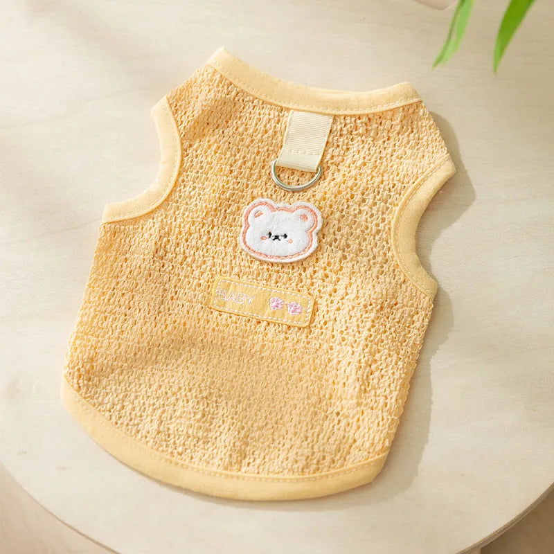 Green knitted cat clothing with a cartoon bear patch, showing hollowed-out breathable fabric.