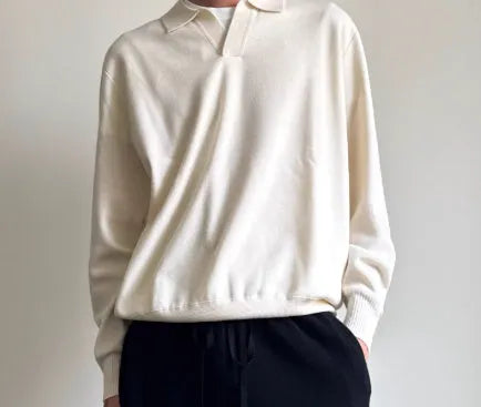 Milky white pure wool lapel collar polo sweater laid flat, showing loose fit and long sleeves.