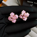 Gold plated stud earrings with a purple oil-spot glaze flower design on a copper base.