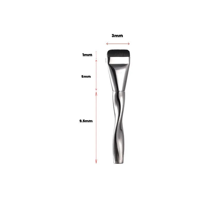 Spiral one-shaped black powder foundation brush with long handle on a white surface next to its storage bag.