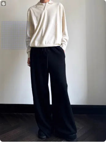 Milky white pure wool lapel collar polo sweater laid flat, showing loose fit and long sleeves.