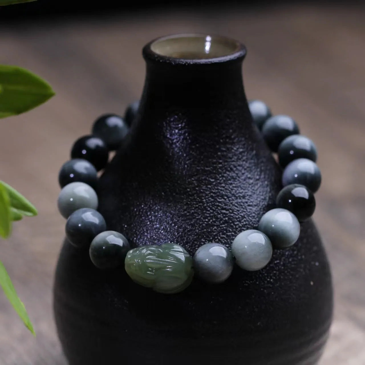 Black bracelet with 10mm Eagle Eye stone beads and a Hetian Jade Pixiu charm.