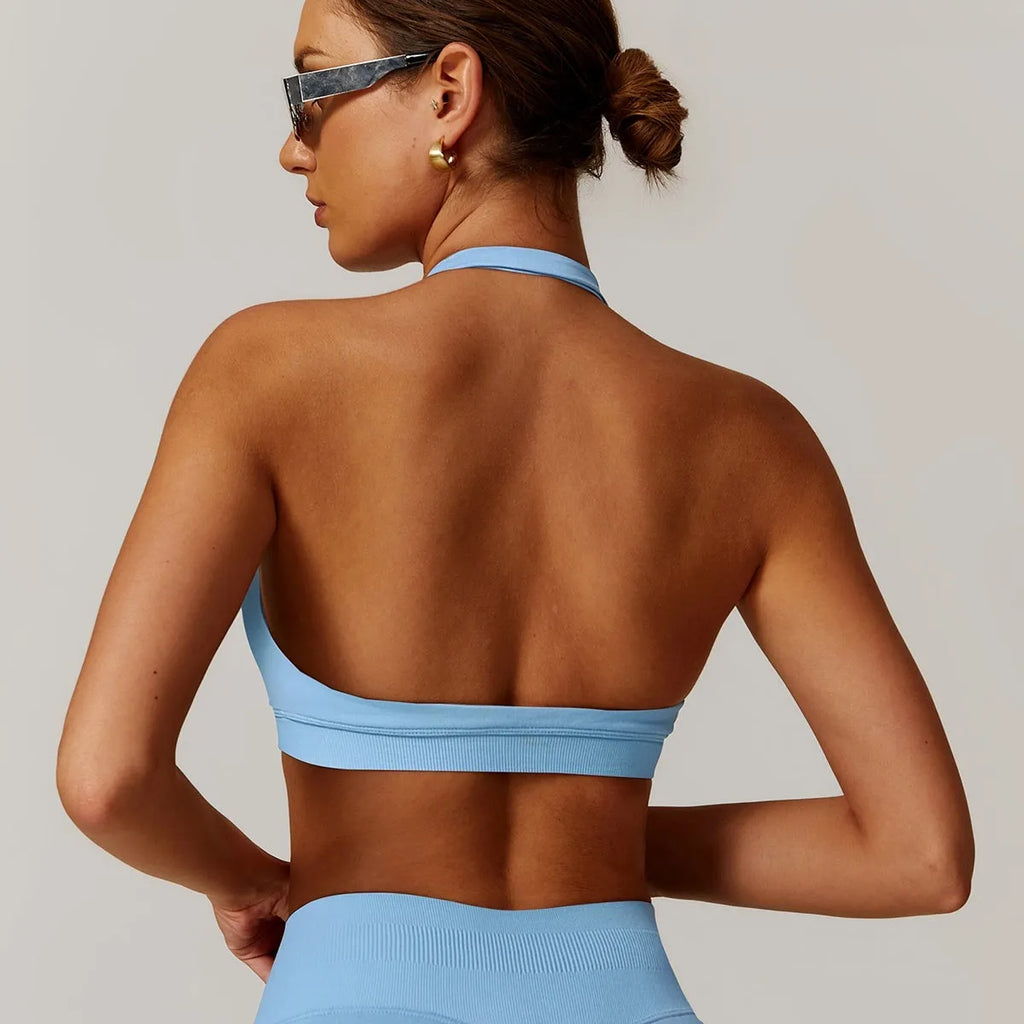 Close-up side view of a black halter neck sports bra for women, showing the strap detail and smooth nylon fabric.